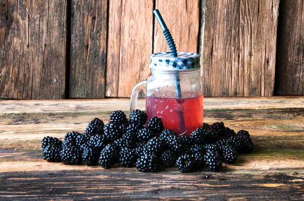 Вкусный ежевичный напиток и фрукты на деревянном фоне — стоковое фото