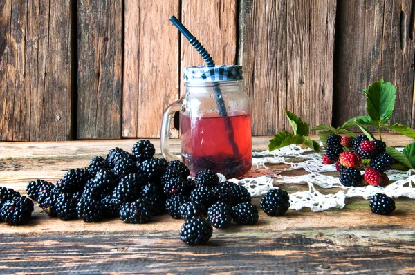 Deliziosa bevanda di more e frutta su sfondo di legno — Foto Stock