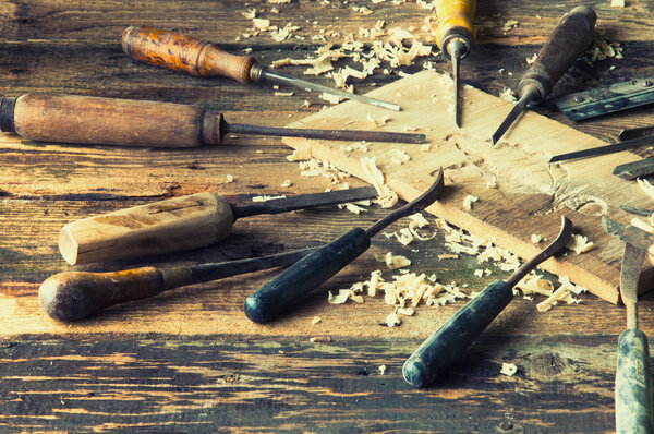 Chisels and carved piece of wood in traditional carpenter workshop