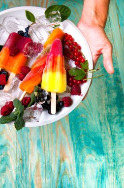 Lezzetli dondurma ve meyve buz küpleri ile hizmet veren eller