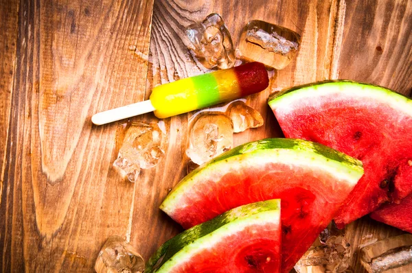 Kousky melounu a zmrzliny na dřevěné pozadí — Stock fotografie