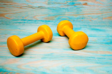 Sarı dumbbells mavi ahşap zemin üzerine 1kg