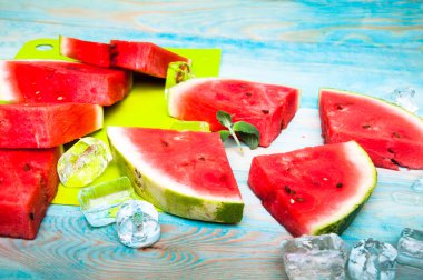 Karpuz mavi ahşap arka plan üzerinde parçaları