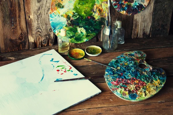 Palettes, brushes and canvas in an old painting workshop — Stock Photo, Image