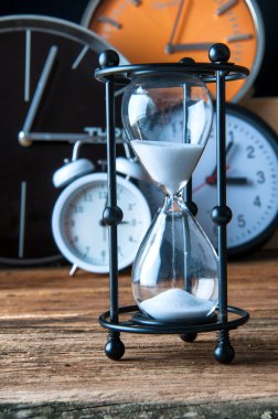 Eski ahşap masa üzerinde kum saati ve Işaretleyerek saatler