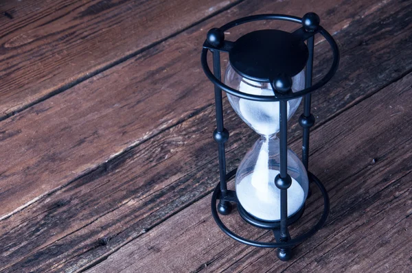 Ahşap arka plan üzerinde kum saati. Boşaltmak