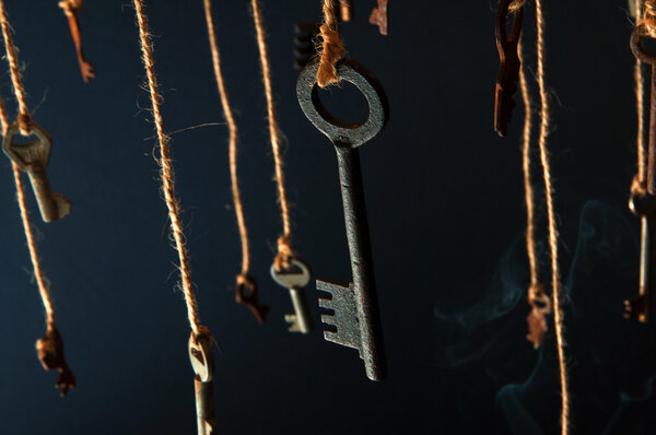Keys hanging on a string. Smoke background. Selective focus
