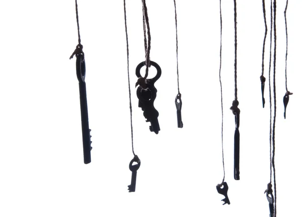 Muchas llaves rústicas colgando de una cuerda. Enfoque selectivo. Aislado — Foto de Stock
