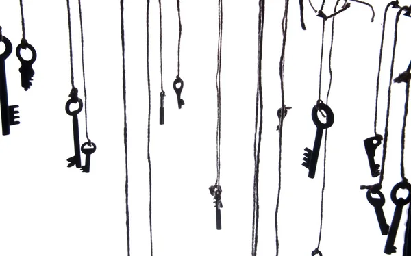 Viele rustikale Schlüssel hängen an der Schnur. Selektiver Fokus. isoliert — Stockfoto