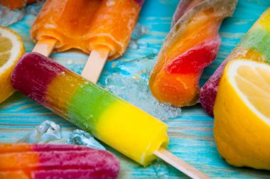 Renkli Buz lolly ve mavi ahşap zemin üzerine friuts