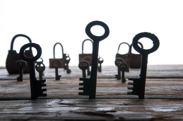 Vecchi lucchetti arrugginiti e chiavi su tavolo di legno bianco — Foto Stock