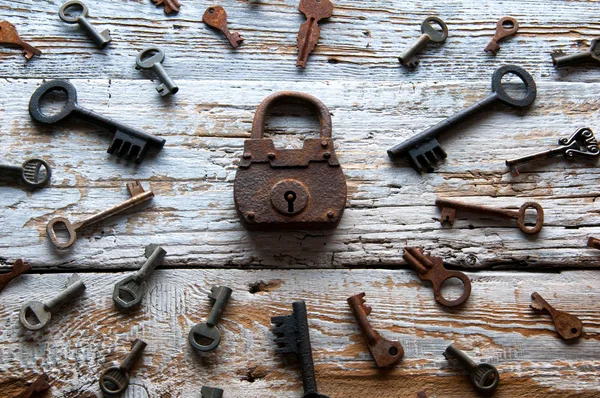 Vecchio lucchetto arrugginito e chiavi su tavolo di legno bianco — Foto Stock