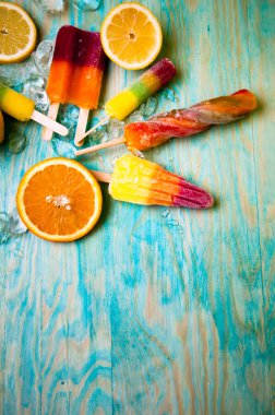 Renkli Buz lolly ve mavi ahşap zemin üzerine friuts