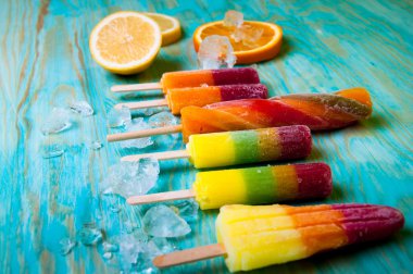 Renkli Buz lolly ve mavi ahşap zemin üzerine friuts