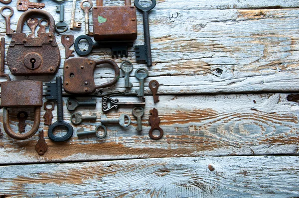 Muitas chaves enferrujadas e cadeados em madeira branca. Espaço de cópia — Fotografia de Stock