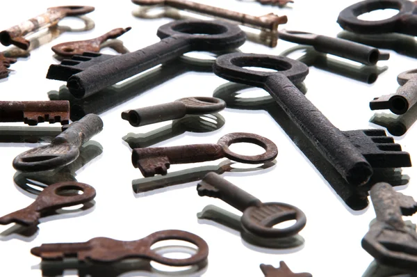 Vecchie chiavi arrugginite su tavolo di legno bianco — Foto Stock