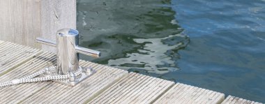 Arka planda mavi deniz suyuyla iskelede bollar