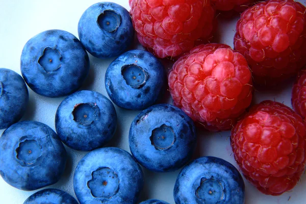 Closeup of a bunch of raspberries and blueberries — Stock Photo, Image