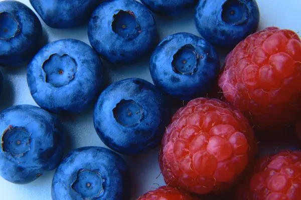 Closeup of a bunch of raspberries and blueberries — Stock Photo, Image