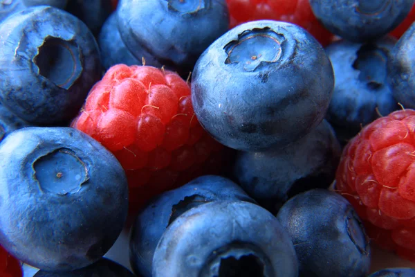 Closeup of a bunch of raspberries and blueberries — Stock Photo, Image
