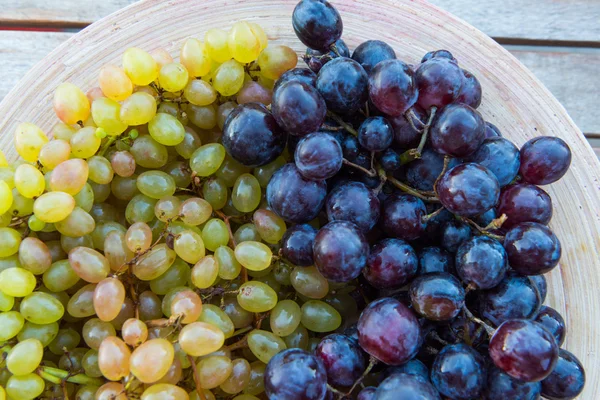 Peaches and grapes in a plate on the table — Stock Photo, Image