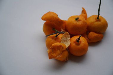 Beyaz arka planda yeşil yapraklı kurutulmuş kayısılar.