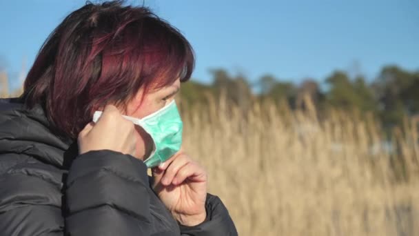 Een dame probeert haar gezichtsmasker op te zetten in Finland. — Stockvideo