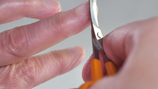 Резка длинных ногтей с помощью маленьких ножниц — стоковое видео