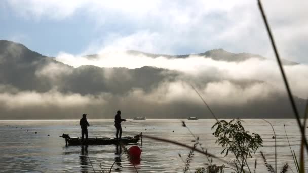 Deux hommes debout sur leur petit bateau dans le lac Kawaguchi près du mont Fuji au Japon — Video