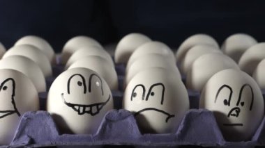 Tepsideki beyaz yumurtalara dört yüz çizilmiş.