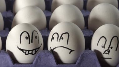 Beyaz yumurtaların üzerindeki yüz çizimleri. 