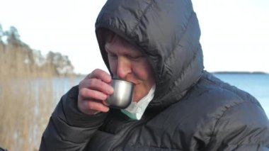 The lady taking off her face mask and drinking in Finland