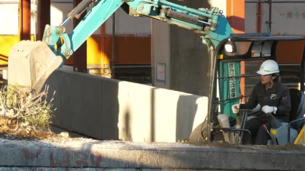 La excavadora azul tratando de conseguir algunas rocas duras en Tokio Japón — Vídeo de stock