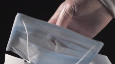 Yüz maskesinin ortasında kutudan çıkan bir delik.