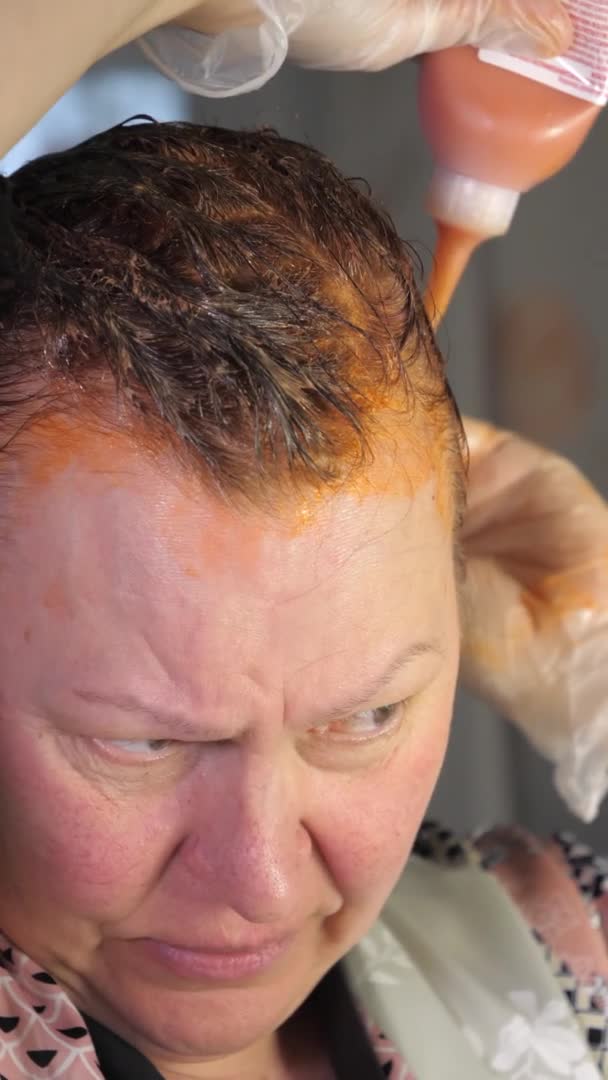 A senhora adulta colocando os produtos químicos de tintura de cabelo. — Vídeo de Stock