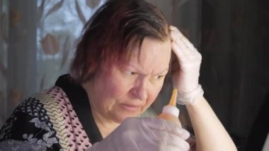 A hair coloring session at home by a mature adult