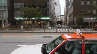 A red taxi on the side of the street in Tokyo Japan