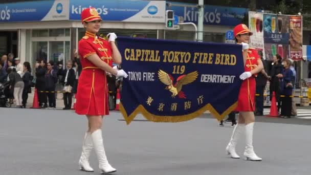 Two ladies in red costume holding a banner during a festival in Tokyo — Stockvideo