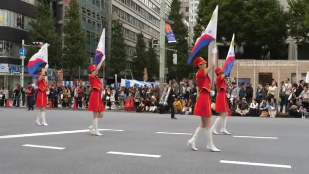 Majoretted держа каждый с флагами на параде — стоковое видео