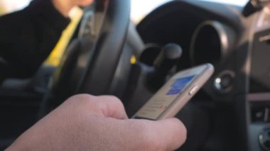 Telefonla mesajlaşırken araba kullanan bir adamın bakışı.