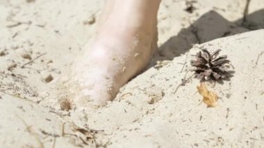 Kum saatine gömülen ayağın daha yakından bak.