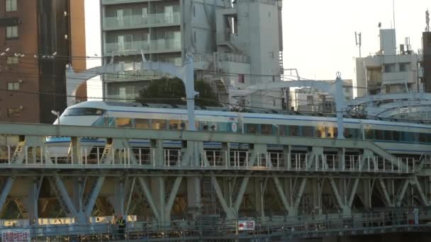 Белый поезд движется в обратном направлении по железной дороге в Токио Япония — стоковое видео