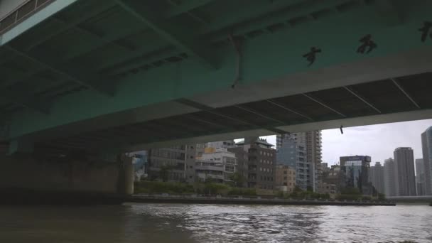 Going under the bridge in Tokyo Japan across the water channel — Stock Video