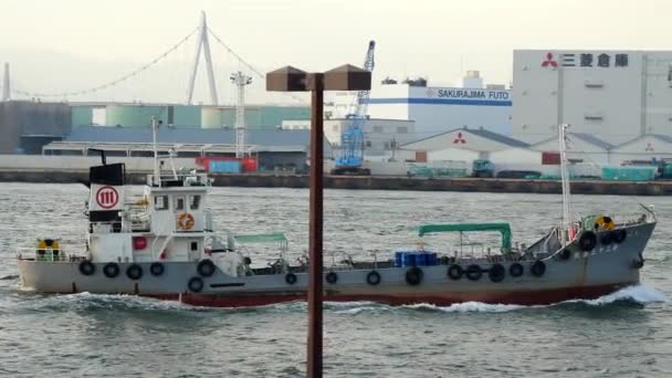 Un barco de pesca en movimiento lento con los neumáticos a un lado en el puerto de Osaka en Japón — Vídeos de Stock