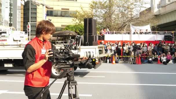 Фотооператор у червоній сорочці на фестивалі в Токіо (Японія). — стокове відео