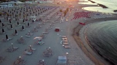 İtalya 'da Rimini kıyılarında masa sandalyeleri ve şemsiyeler