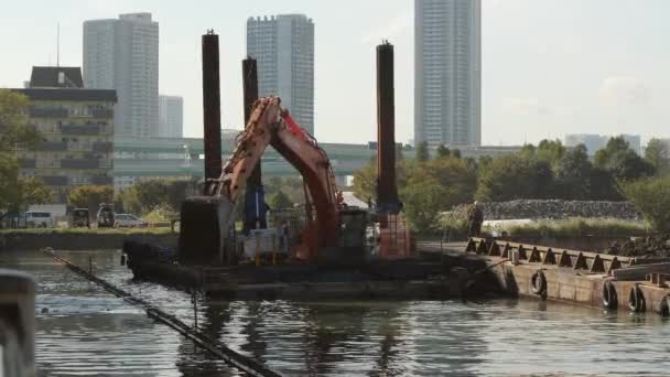 A moving bulldozer on the river construction near the Tokyo Swimming Center — Stock Video