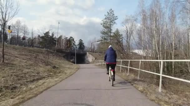 La signora di mezza età in bicicletta per le strade di Vantaa Finland.4K — Video Stock