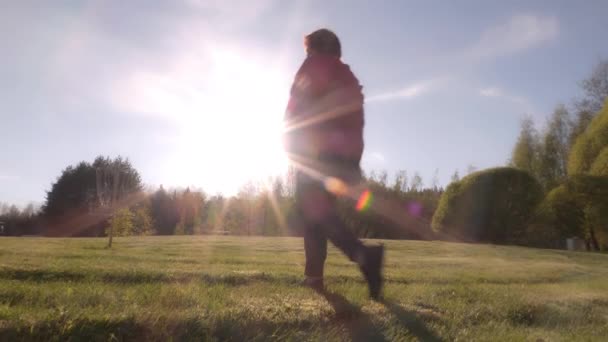 Idylický záběr na dámu středního věku procházející se v parku za slunečného dne. — Stock video