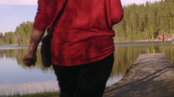 Piękne ujęcie kobiety w średnim wieku wchodzącej na pływający most. — Wideo stockowe